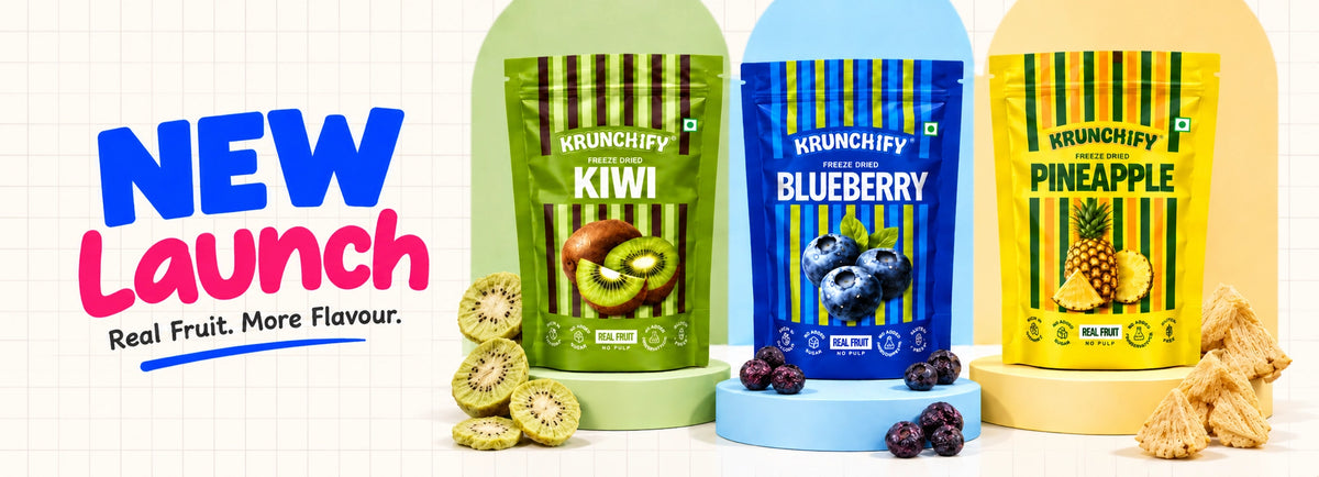 Three snack pouches from Krunchify are shown in a promotional layout: Kiwi, Blueberry, and Pineapple flavors. The image features large text reading 'NEW Launch' on the left, kiwi slices on the left side, and pineapple crisps on the right side.